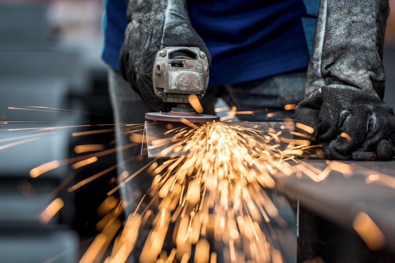 Worker on a grinder with sparks flying. | Newsreel