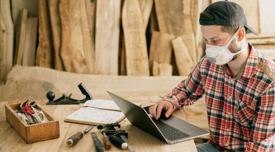 Man on laptop in carpentry business. | Newsreel