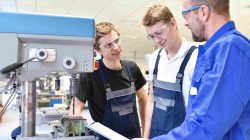 Man training students in workshop. | Newsreel