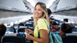 Woman walking down aisle of a airplane. | Newsreel