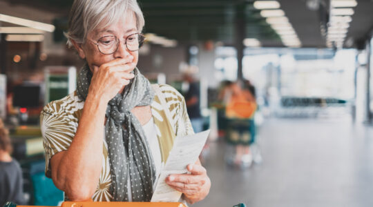 Worried woman looks at shopping receipt. | Newsreel