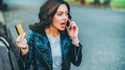 Women talking on phone holding credit card. | Newsreel