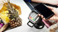 Mobile phone being used to make EFTPOS purchase. Newsreel