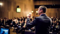 Man talking to crowd at conference. | Newsreel