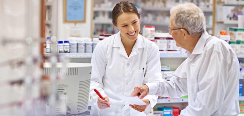 Elderly man with female pharmacist at chemist. | Newsreel