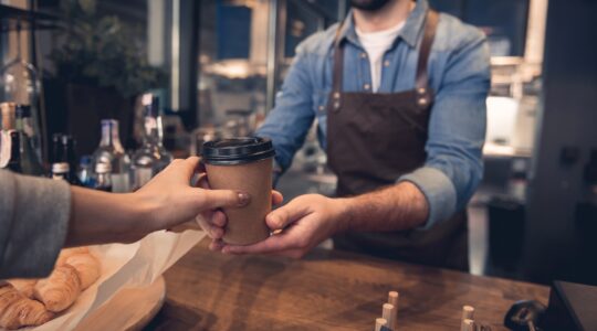 Barista serving customer takeaway coffee. | Newsreel