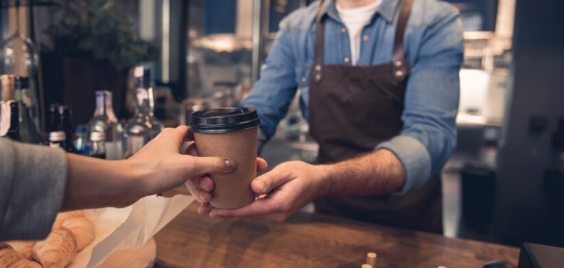Barista serving customer takeaway coffee. | Newsreel
