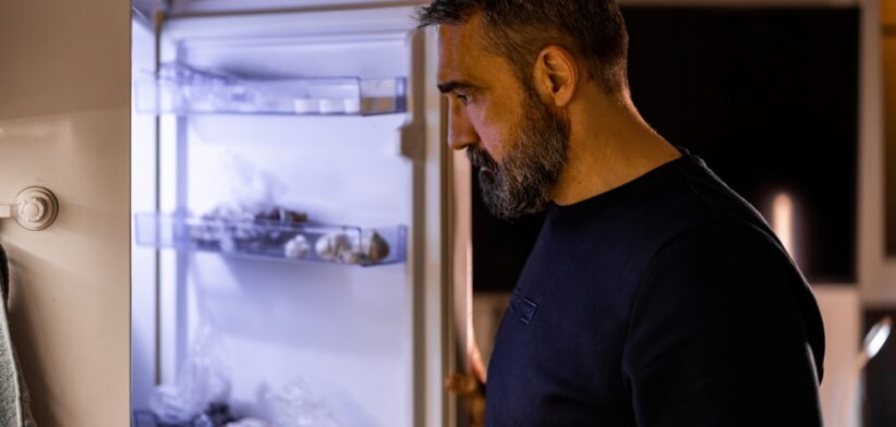 Depressed man looking into fridge. | Newsreel