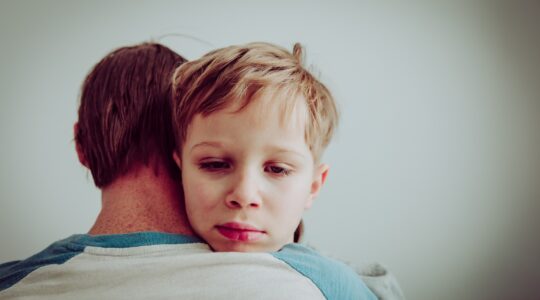 Child comforted by adult. | Newsreel