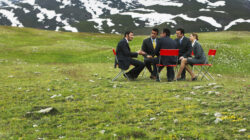 Meeting around table in field. | Newsreel