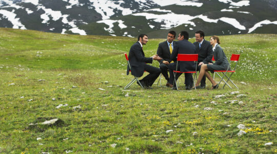 Meeting around table in field. | Newsreel