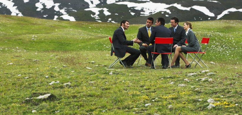 Meeting around table in field. | Newsreel