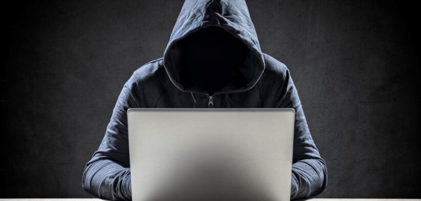 Man in hoodie scamming on computer.| Newsreel
