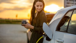 Woman charging electric vehicle. | Newsreel