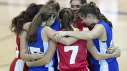 Basketball team hugs on court. | Newsreel