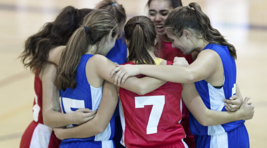 Basketball team hugs on court. | Newsreel