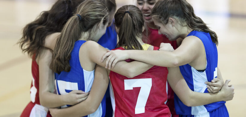 Basketball team hugs on court. | Newsreel