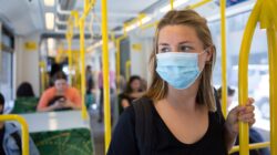 Woman on train wearing mask. | Newsreel