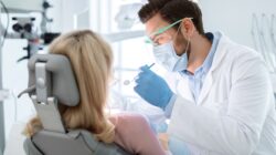 Dentists with patient in dental chair. | Newsreel