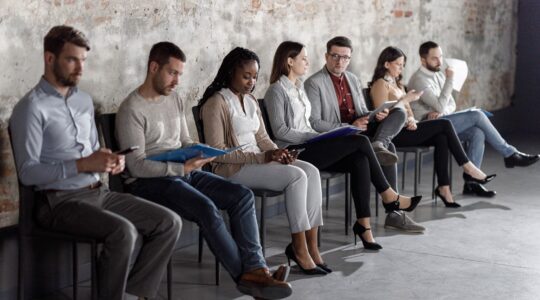 People waiting on chairs.| Newsreel