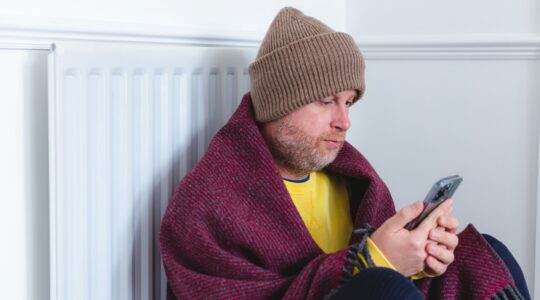 Man rugged up in cold house. | Newsreel