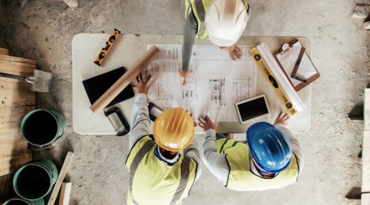 Workers looking over housing plans