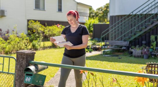 Woman getting mail out of letterbox. | Newsreel