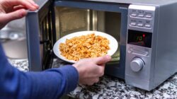 Man putting meal in microwave oven. | Newsreel