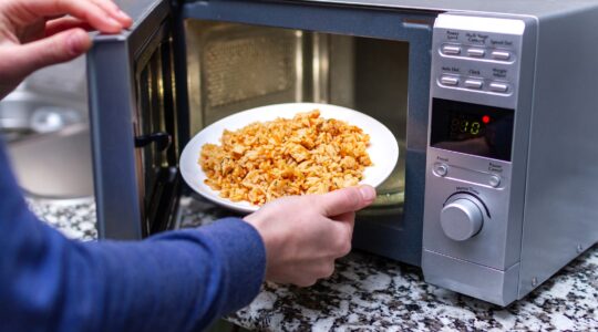 Man putting meal in microwave oven. | Newsreel