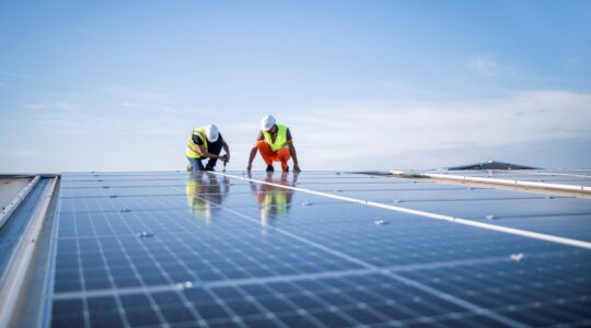 Workers installing solar panels. | Newsreel