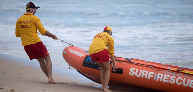 Queensland surf lifesavers pulling boat out of water. | Newsreel