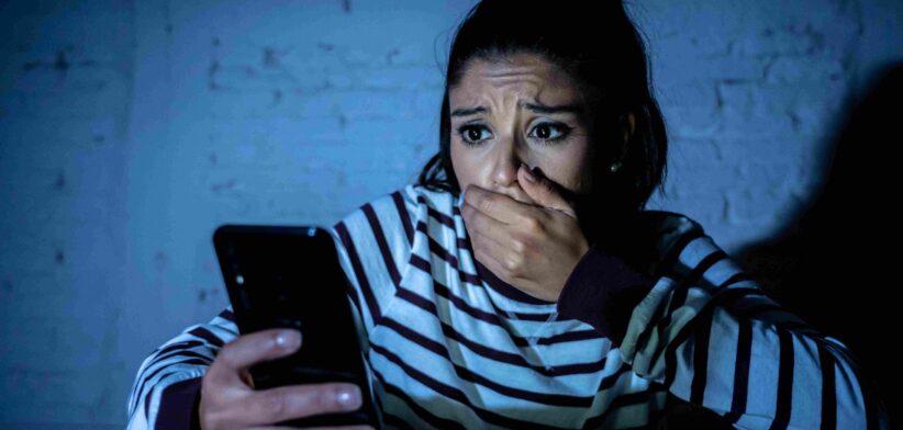 Woman shocked looking at phone. | Newsreel