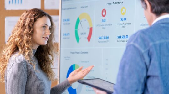 Woman and man looking at business charts.