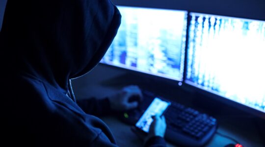 Hooded man in front of computer