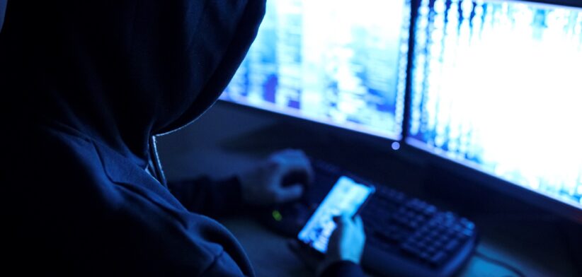 Hooded man in front of computer