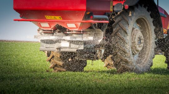 Tractor spreading fertiliser. | Newsreel