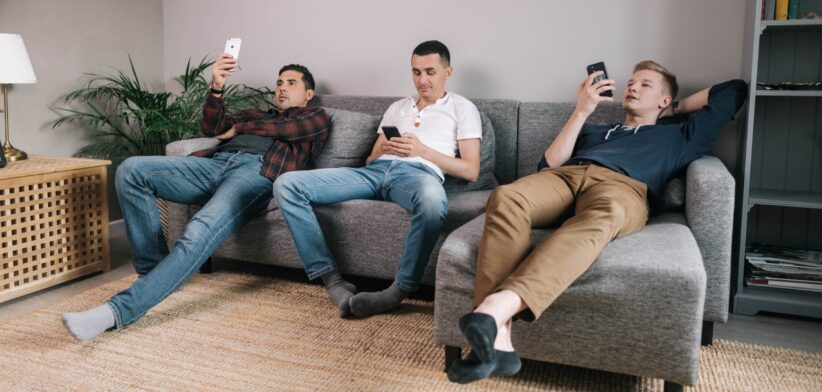 Three men sitting in couch on phones. | Newsreel