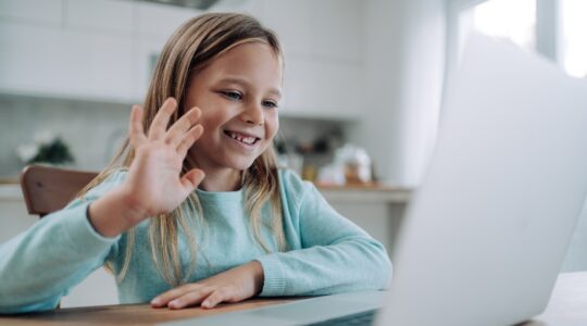 Young children on laptop talking to someone. | Newsreel