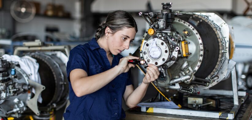 Female tradie working on machinery. | Newsreel