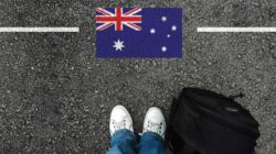 Feet of person about to cross line with Australian flag. | Newsreel