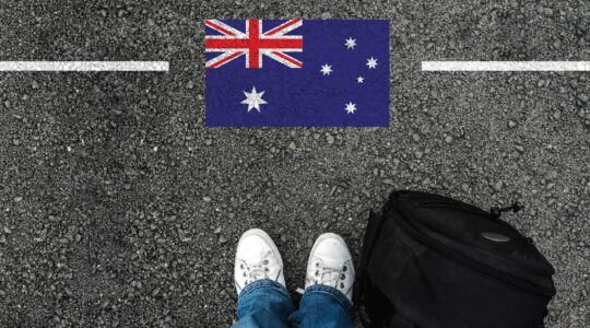 Feet of person about to cross line with Australian flag. | Newsreel