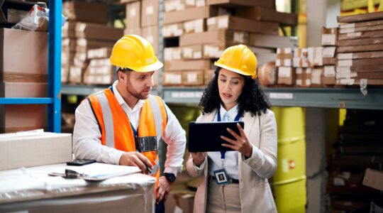 Man and woman in warehouse. | Newsreel