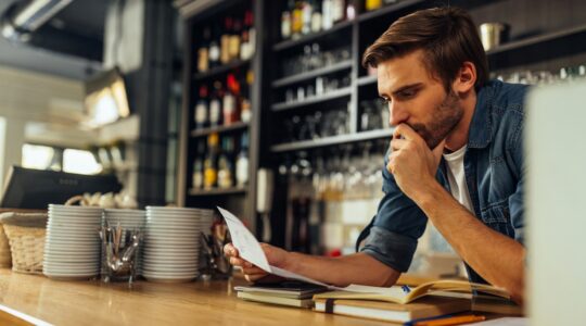 Business owner looking at bill. | Newsreel