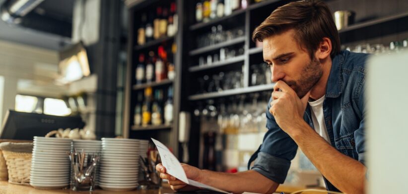 Business owner looking at bill. | Newsreel