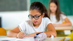 Child writing in classroom. | Newsreel