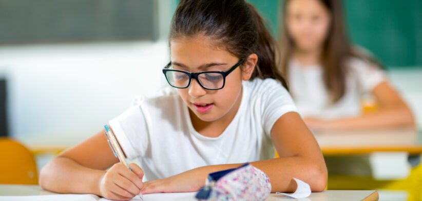 Child writing in classroom. | Newsreel