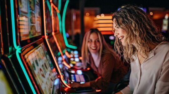 Two women at poker machines. | Newsreel