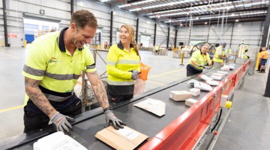 Australia Post staff at Gold Coast parcel sorting facility. | Newsreel