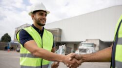 Men shaking hands on work site. | Newsreel