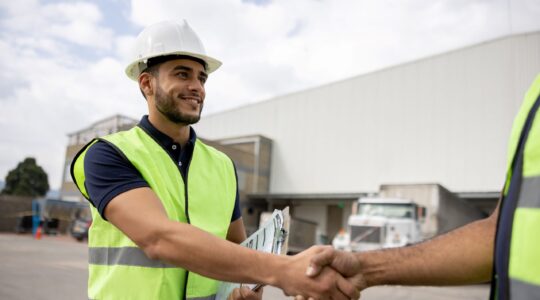 Men shaking hands on work site. | Newsreel